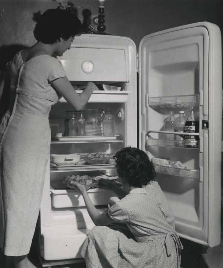 Two Women Arranging Products in the Refrigerator. USA 1950s Two Women Arranging Products in the Refrigerator. USA 1950s